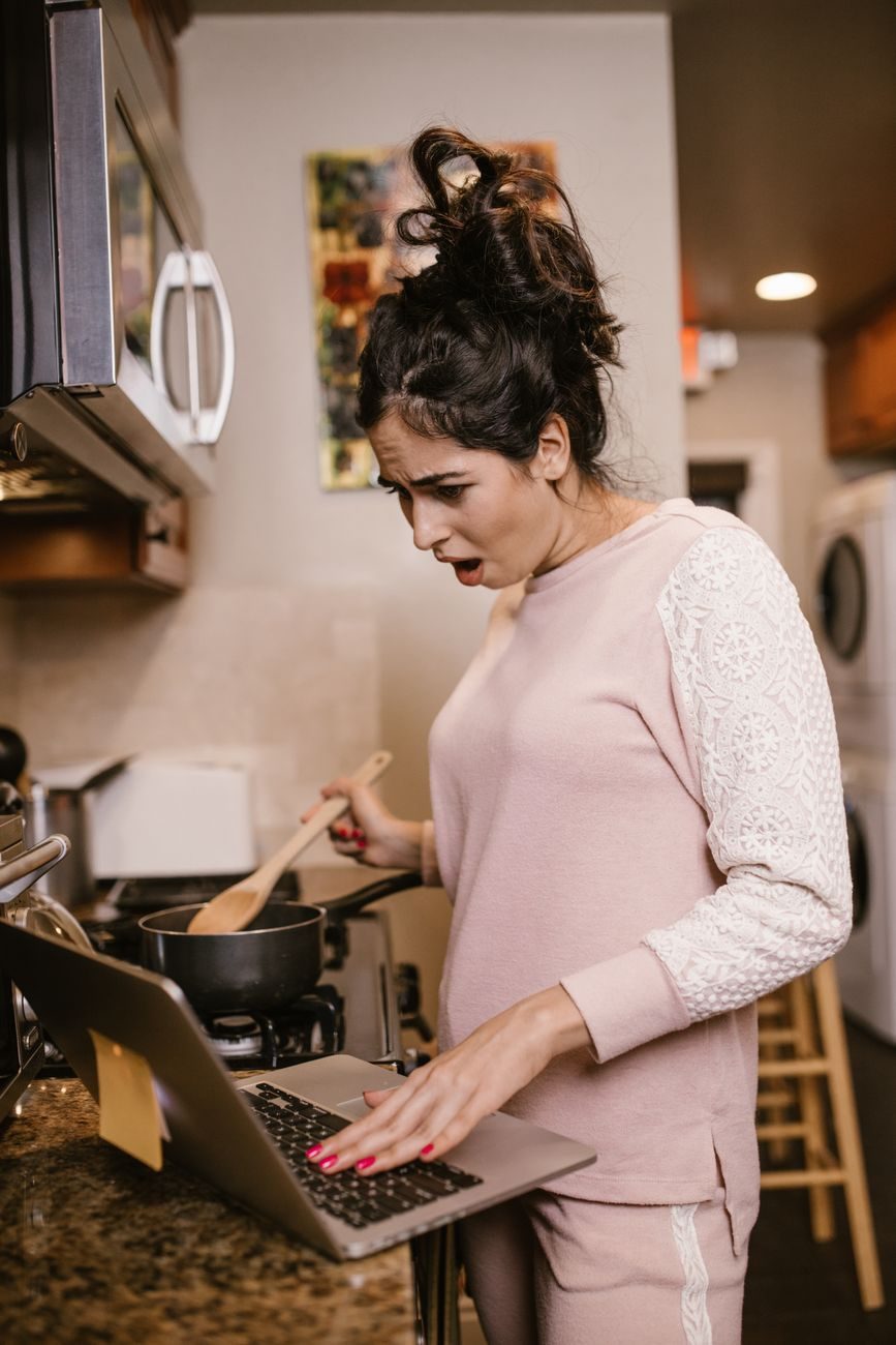 Woman recoiling in shock in her kitchen